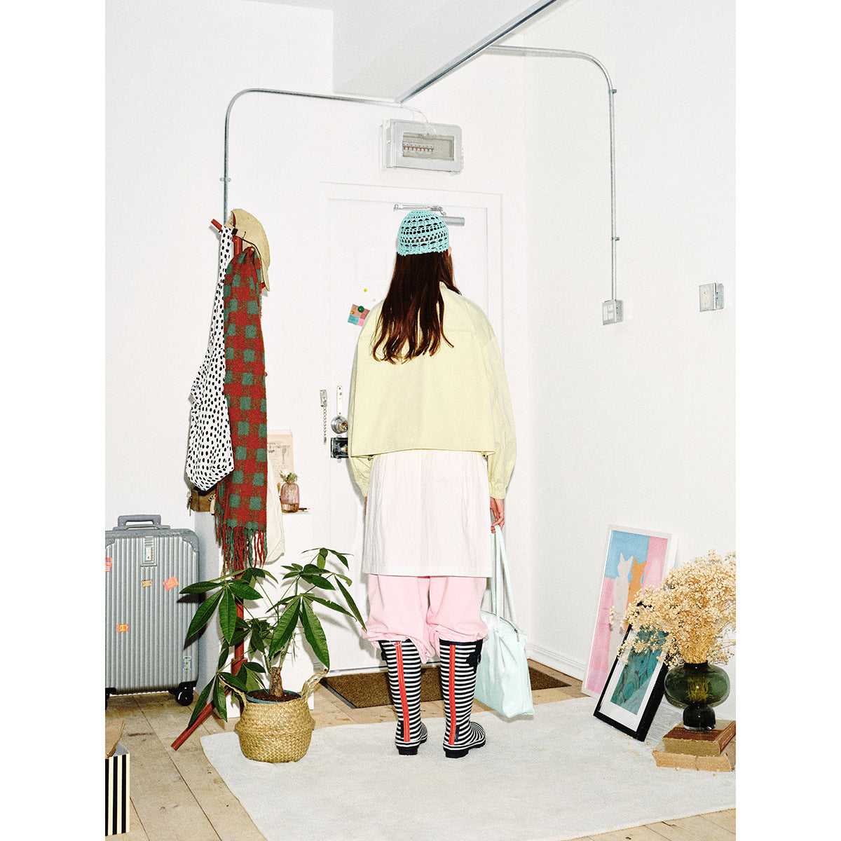 Back view of a model wearing a pale yellow cropped jacket with gathered cuffs.