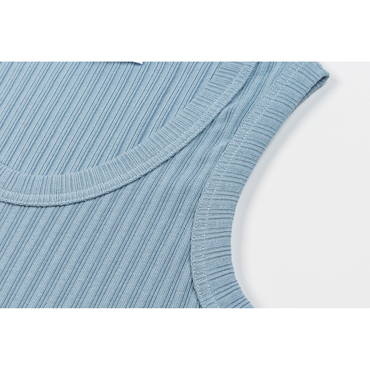 Close-up of a light blue ribbed tank top showing its scoop neckline and bound armhole.
