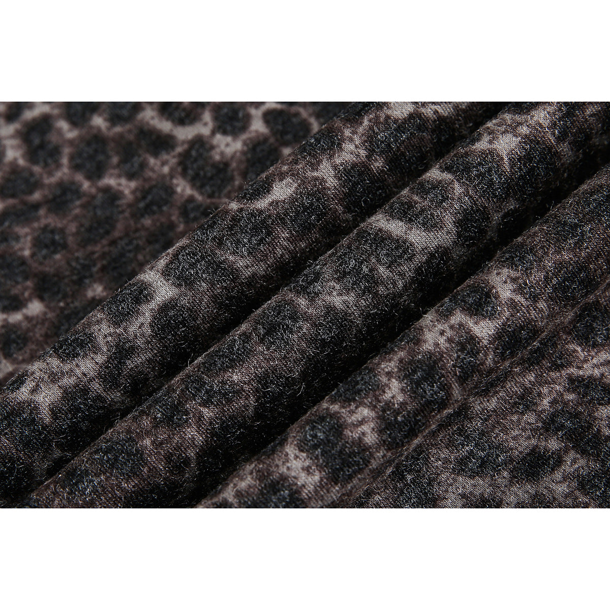 Macro view of the dark brown and black leopard print and fabric texture.