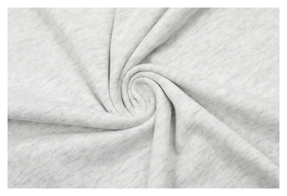 Close-up of light gray heathered fabric gathered into a swirl to show its texture.
