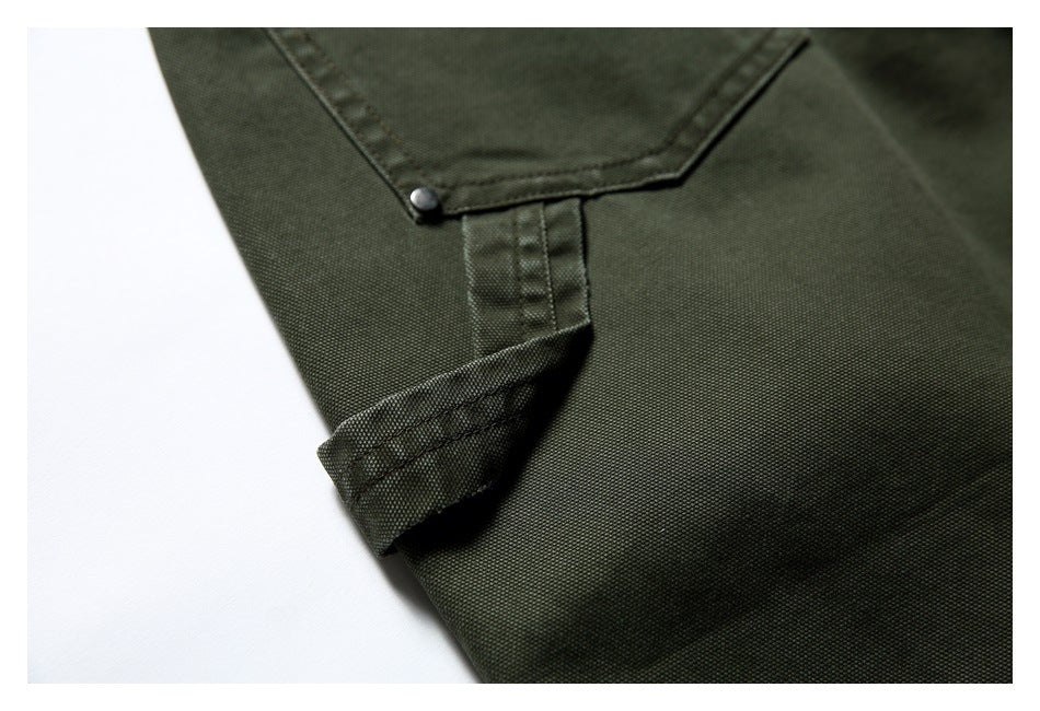 Close-up of an olive trouser pocket corner, metal rivet and folded stitched fabric tab.
