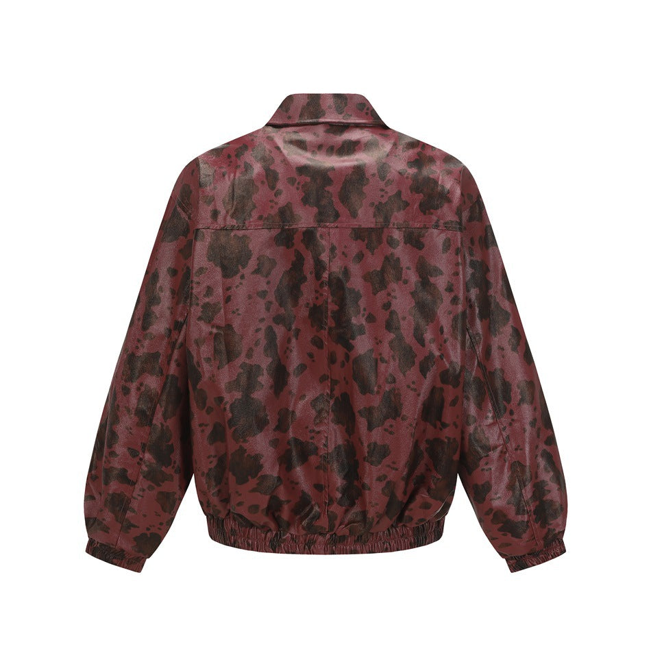Back view of a burgundy jacket with dark irregular spots, a pointed collar, long sleeves, and an elastic hem.