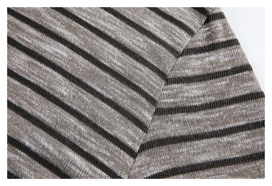 Close-up of a seam joining two sections of a gray and black striped knit garment.