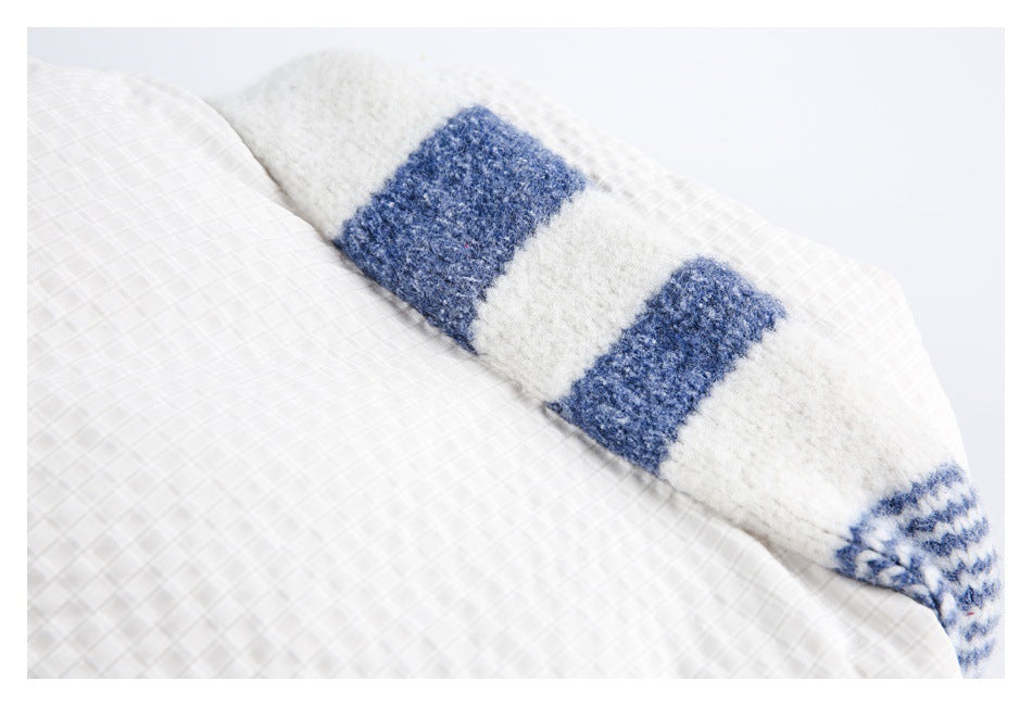 Close-up of a fuzzy blue-and-white striped lining beside the garment's pale check exterior.