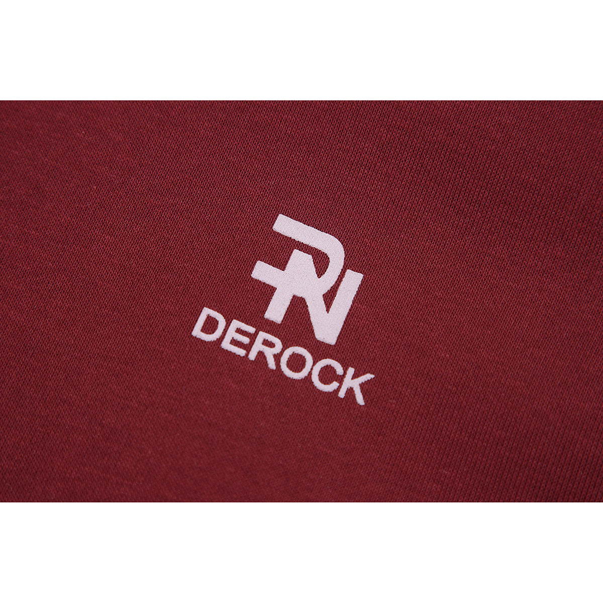Close-up of a white DERОCK logo on burgundy knit fabric.