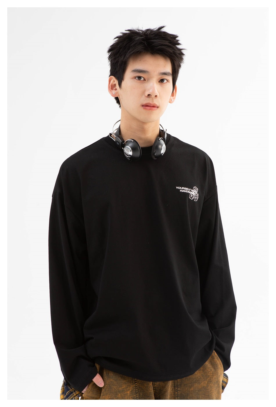 Model wearing a black long-sleeve crew-neck shirt with a small white dice graphic and text on the chest.