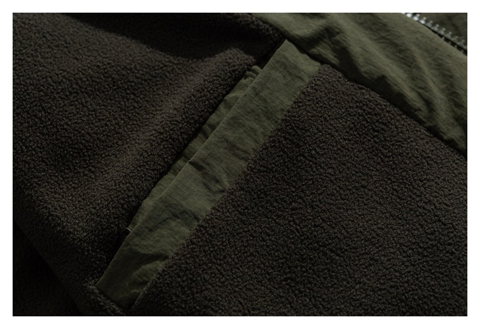 Close-up of dark textured garment fabric with an olive green panel or seam.