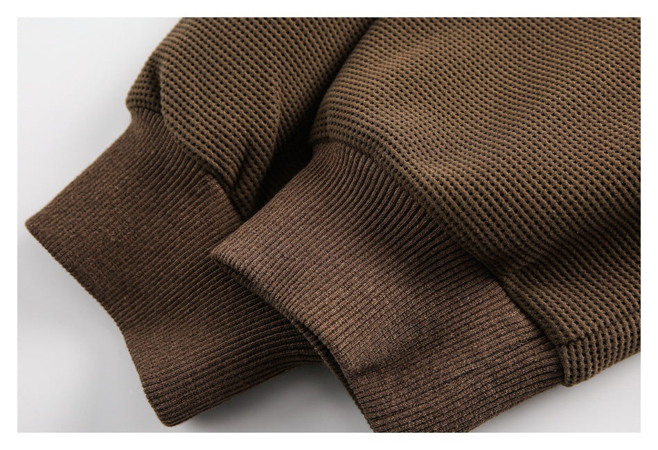 Close-up of the brown waffle-knit top's wide ribbed sleeve cuffs.
