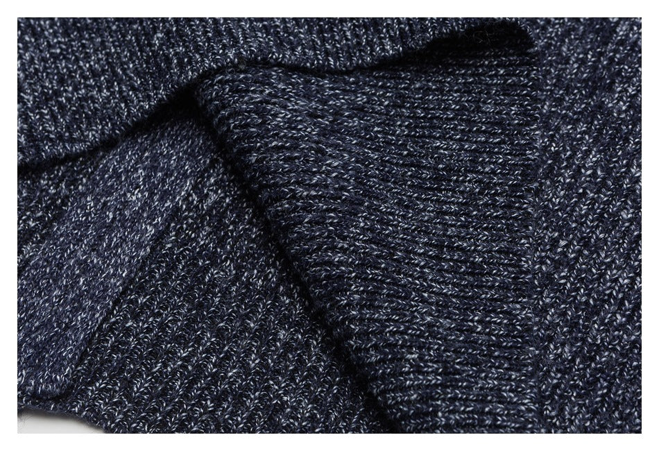 Close-up of folded dark navy marled knit fabric with a ribbed edge.