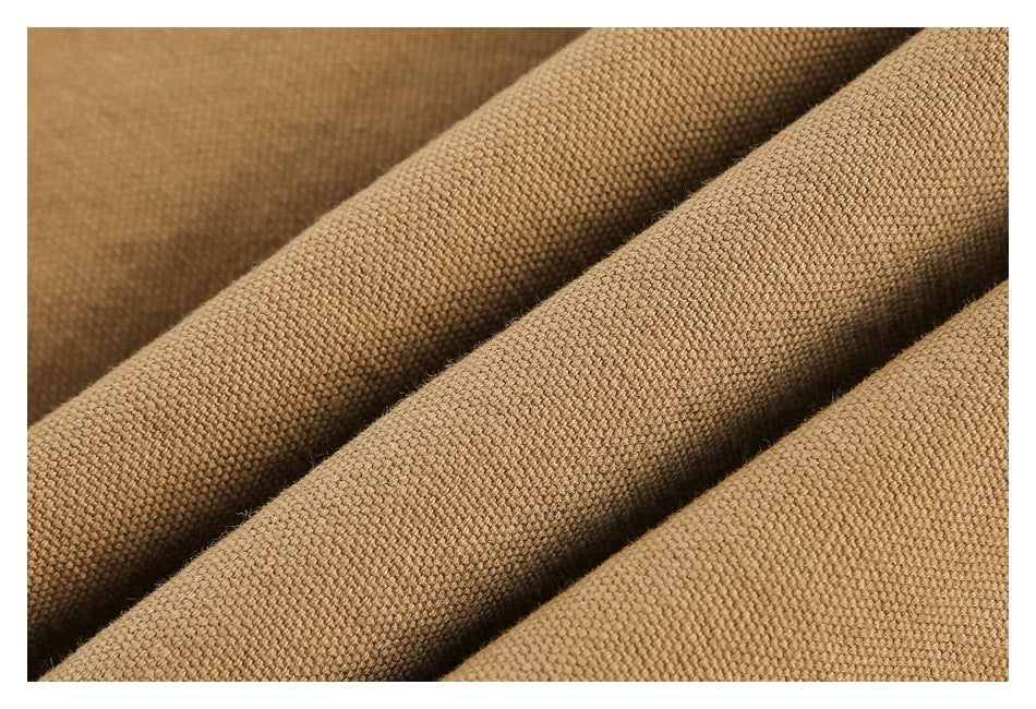 Macro view of the textured weave of camel-brown garment fabric in soft folds.