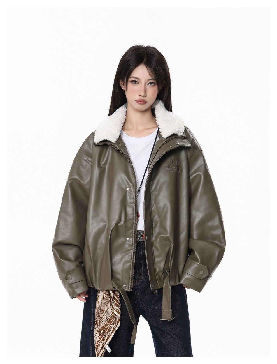 Model wearing the dark green jacket open with the fleece-like collar folded out, over a white tee and jeans