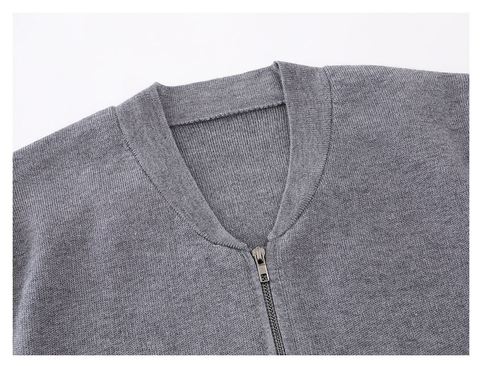 Close-up of a gray knit cardigan's V-neck collar and front zipper.