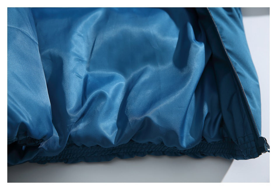 Close-up of the blue jacket's gathered elastic hem beside the zipper.