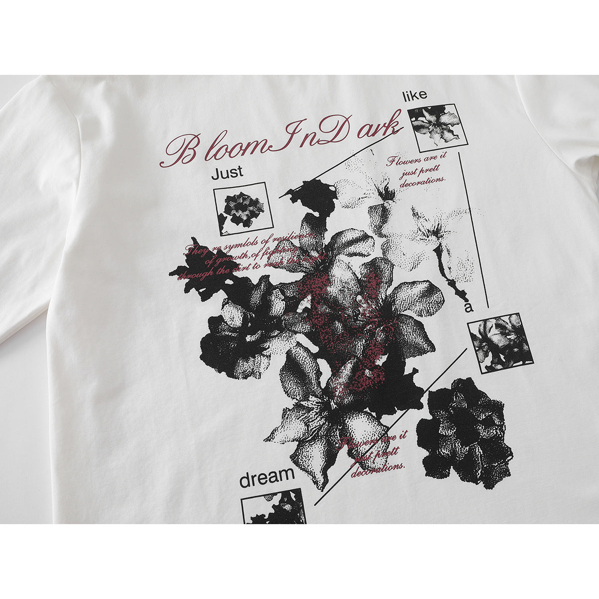 Close-up of a white T-shirt’s large black floral graphic with red accents and English lettering.