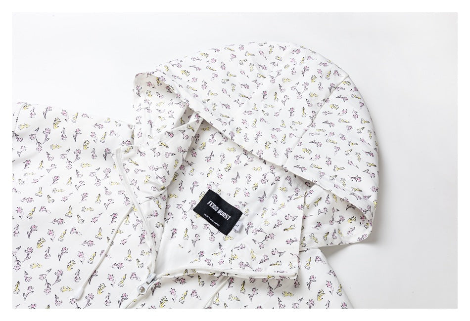 Close-up of the jacket's floral-print hood, drawcord, and sewn black neck label.