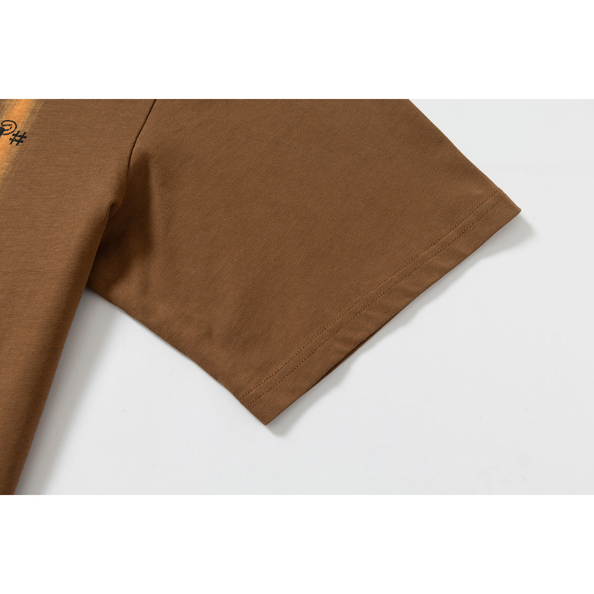 Close-up of the short sleeve and double-stitched hem on a brown T-shirt.
