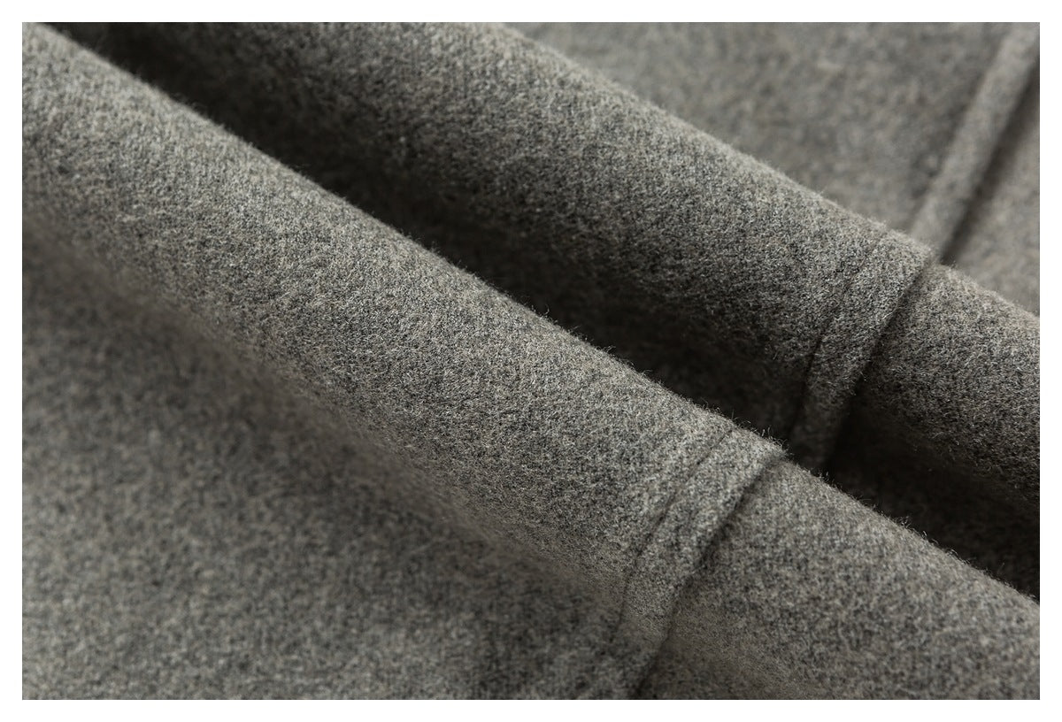 Close-up of gray heathered fabric folds with a stitched seam.