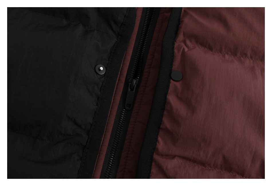 Close-up of the jacket's black zipper and snap closures between black and muted burgundy panels.