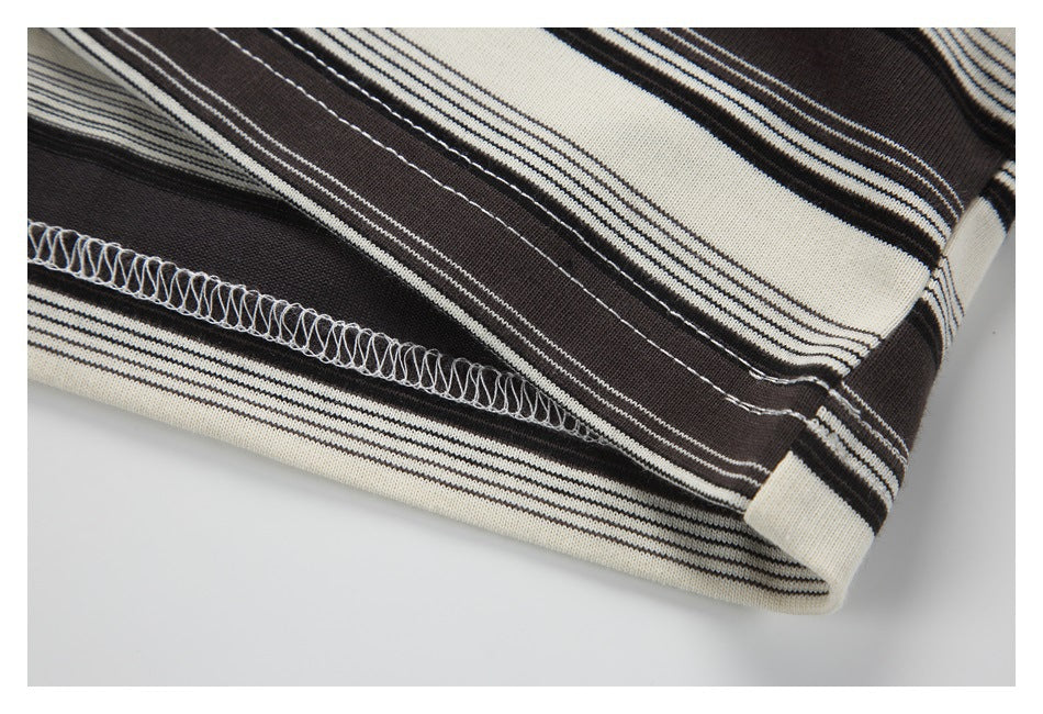 Close-up of a striped garment hem showing its overlock stitching and folded edge.