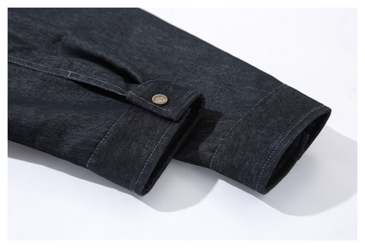 Close-up of a dark indigo cuff with a buttoned adjustment tab and stitched hem.