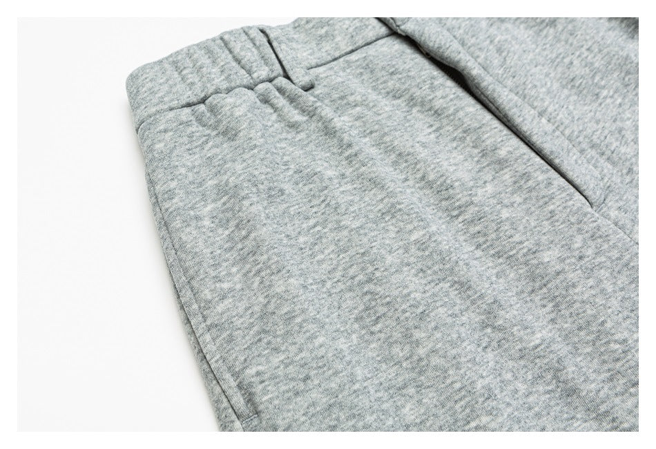 Close-up of heather gray pants showing a belt loop, waistband, and side pocket seam.
