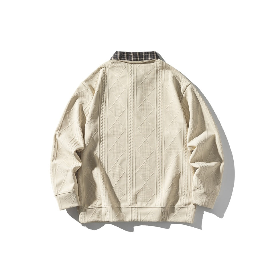 Back view of a cream pullover laid flat, showing a plaid collar and raised cable and diamond patterns.