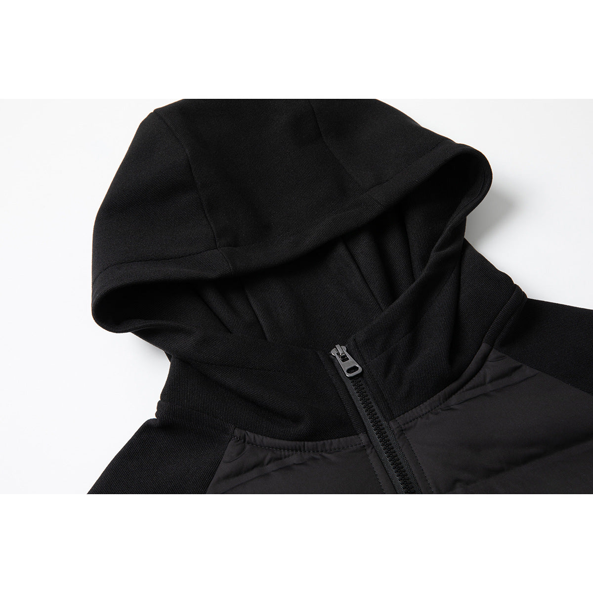 Close-up of a black hooded jacket showing the hood, front zipper, and quilted body panel.