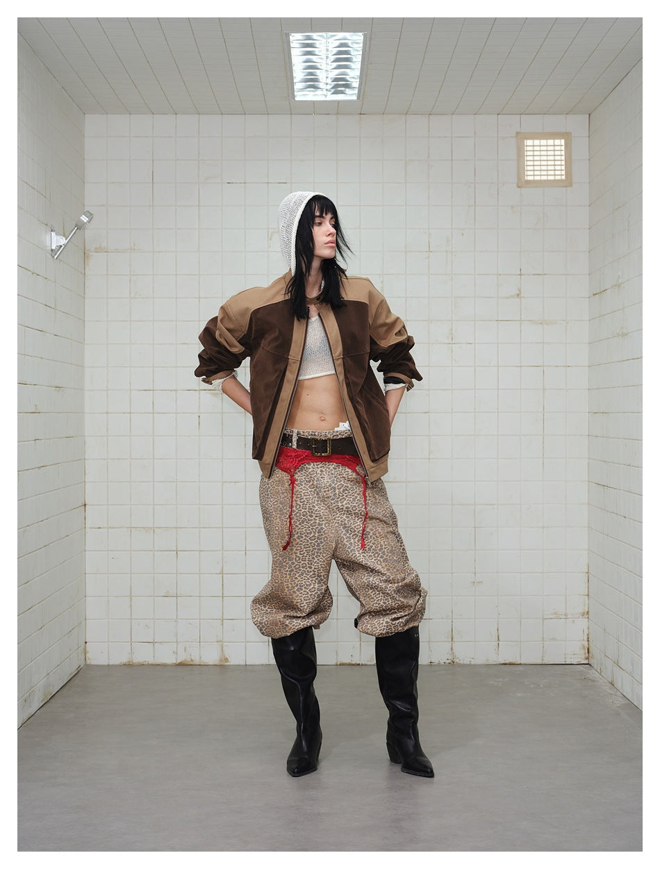 Model with hands on hips wearing the open brown and tan color-block jacket, leopard trousers and boots