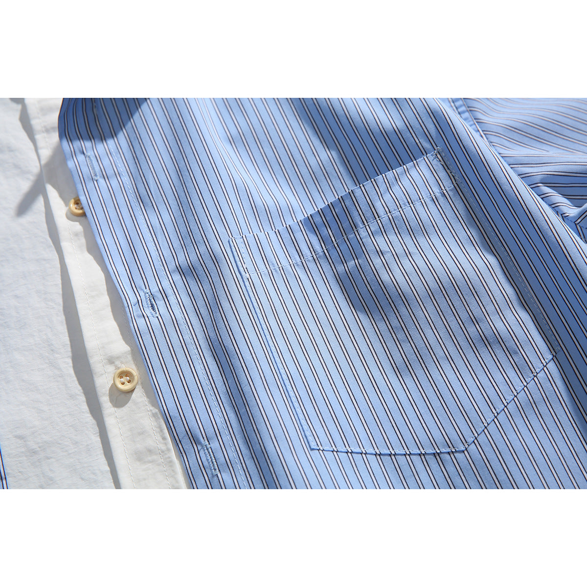 Close-up of the shirt's light blue striped chest pocket, stitching, and tan buttons.