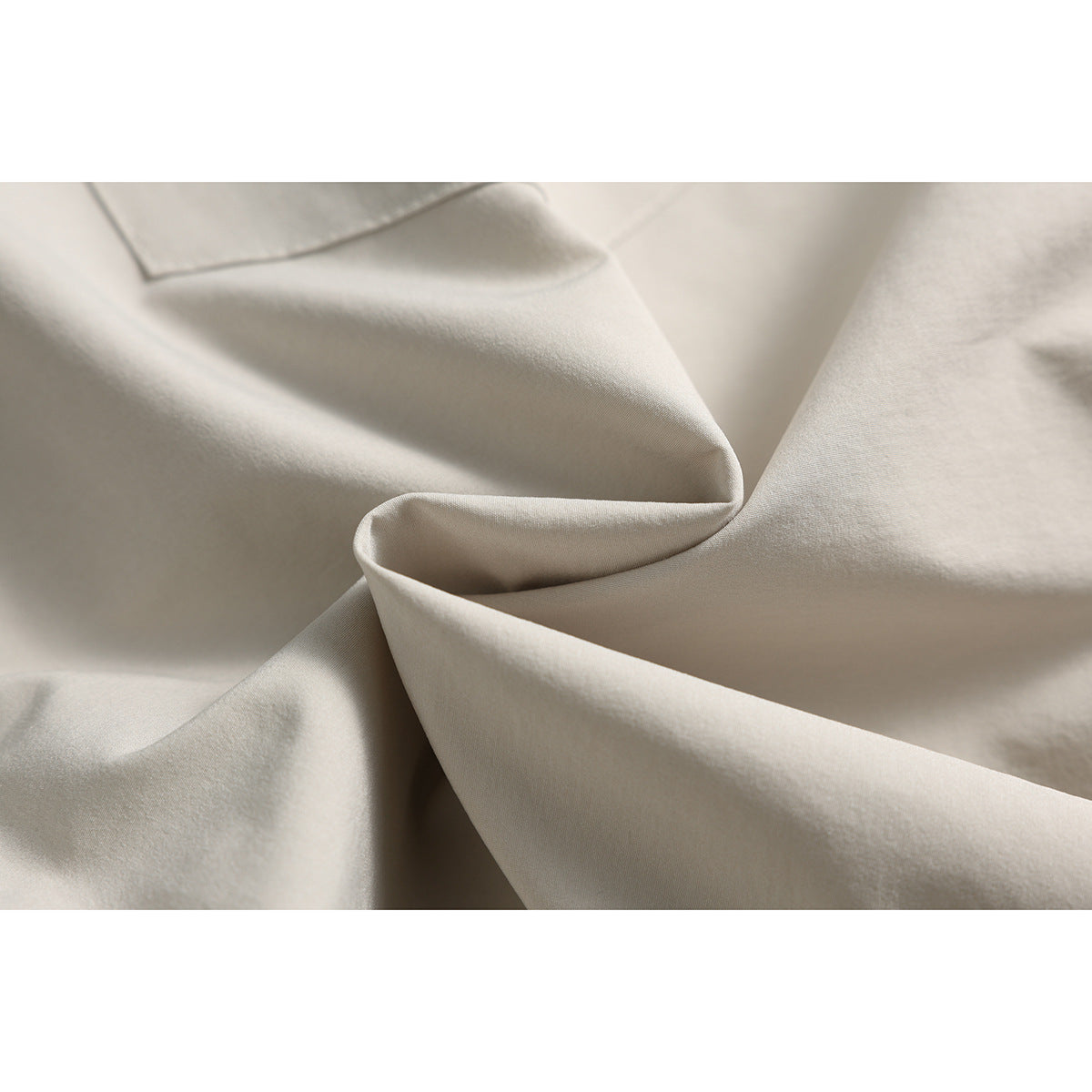 Close-up of beige shorts fabric draped to show its surface and folds.