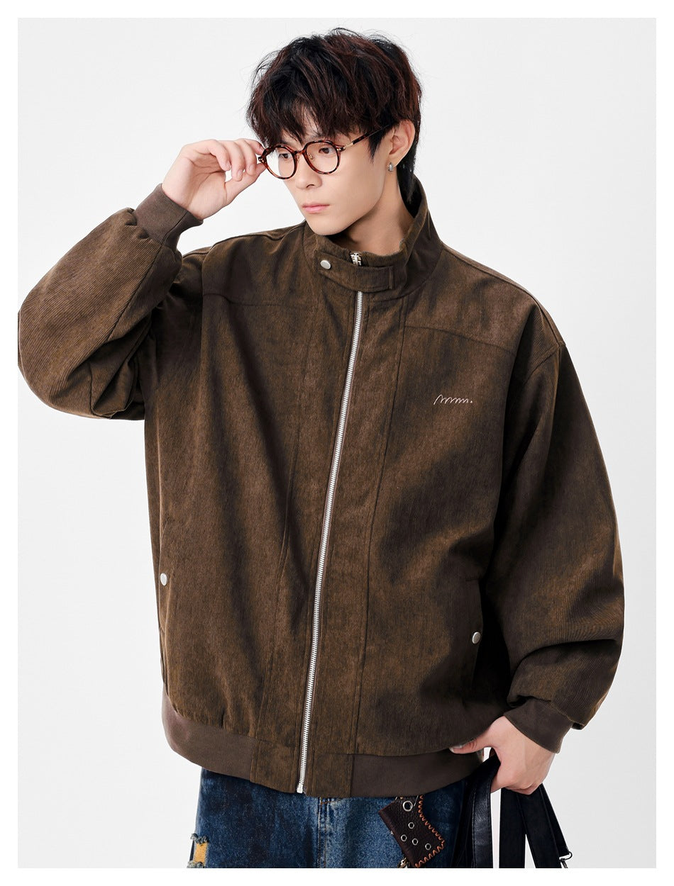 Model wearing a dark brown zip-front jacket with a stand collar, ribbed cuffs and hem, and small chest embroidery.