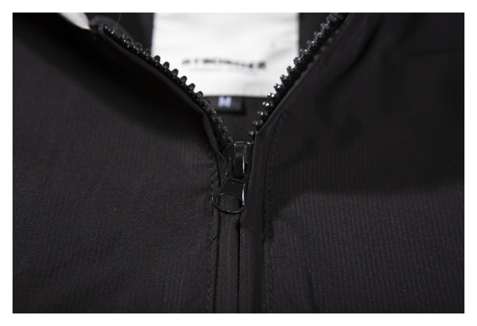 Close-up of a black zipper and pull on a black garment.