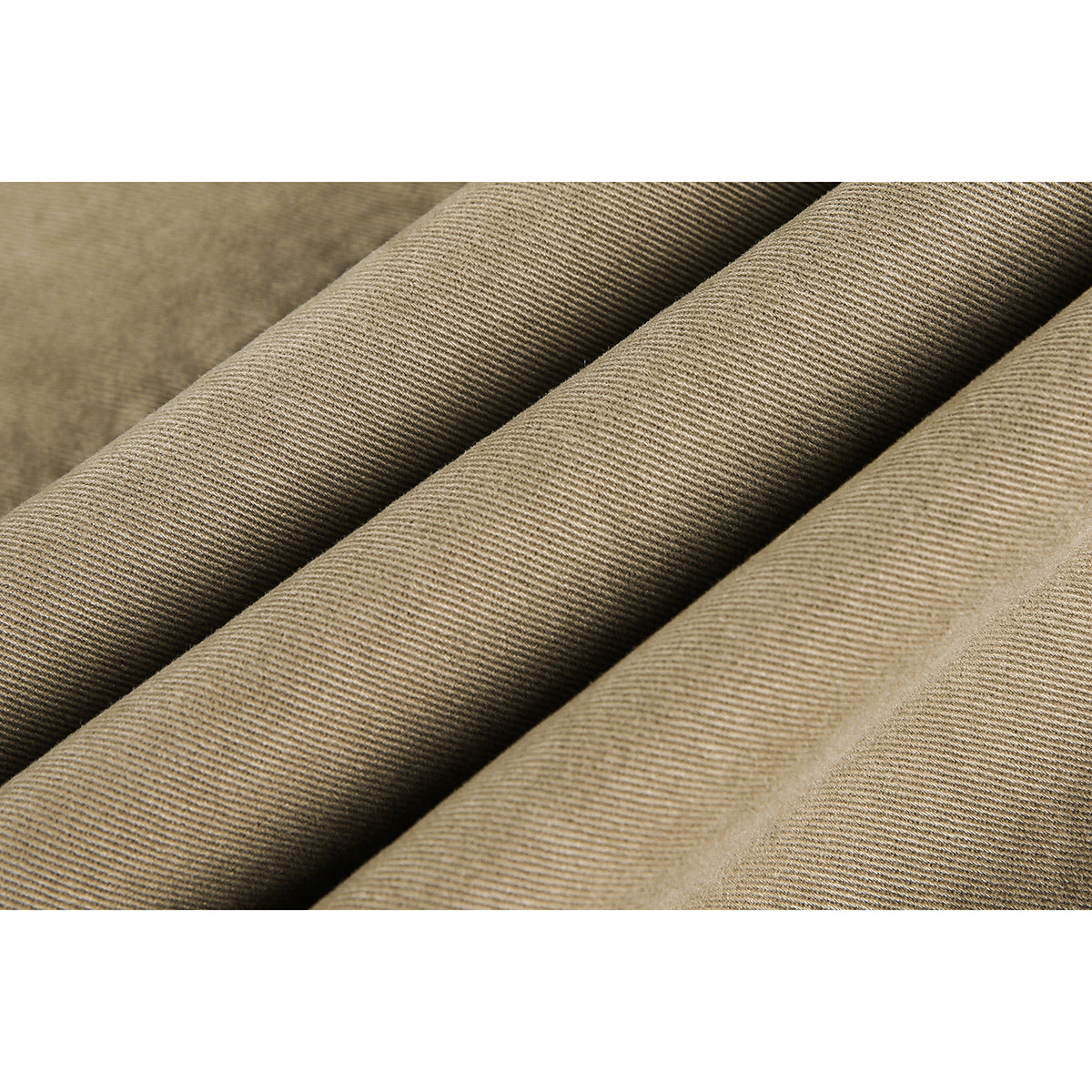 Macro view of tan fabric folded into diagonal ridges, showing its fine twill weave.