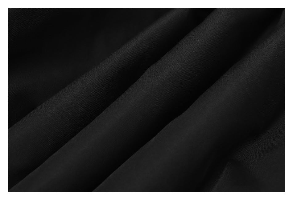 Extreme close-up of the black jacket fabric in soft folds.