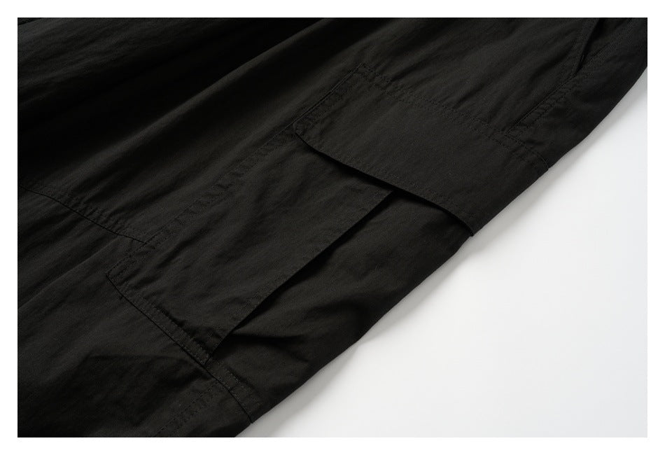 Close-up of a flap cargo pocket and stitching on black pants.