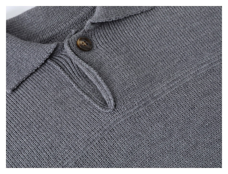 Angled close-up of the gray sweater's pointed collar, brown button, and placket.