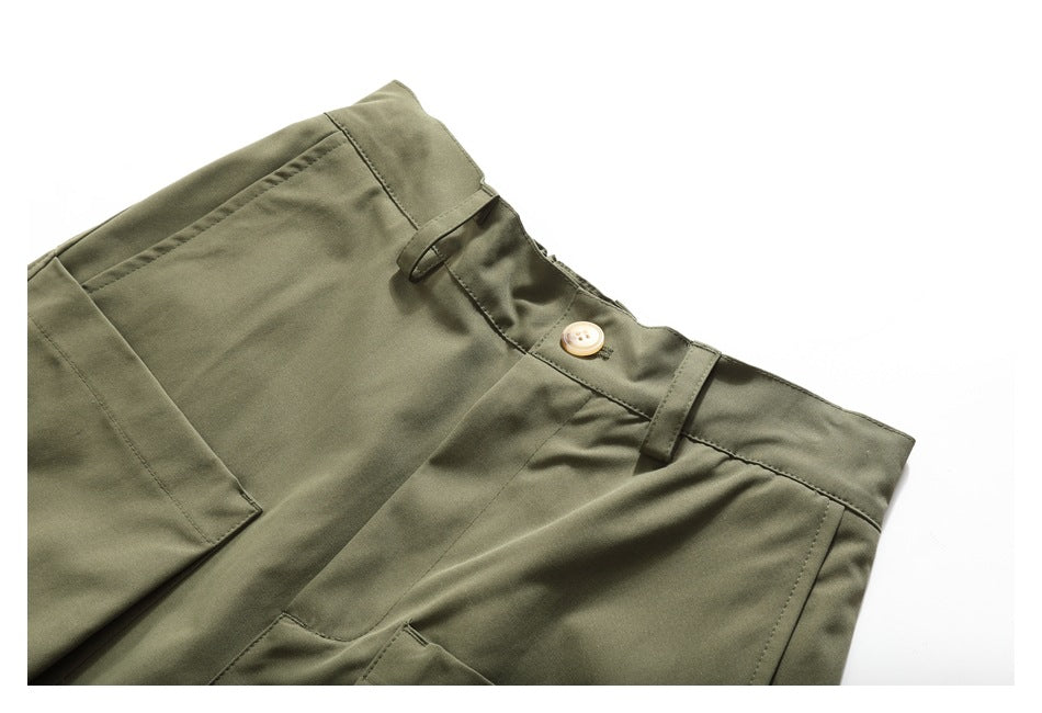 Angled close-up of olive-green trousers showing the waistband, button, belt loops, and pockets.