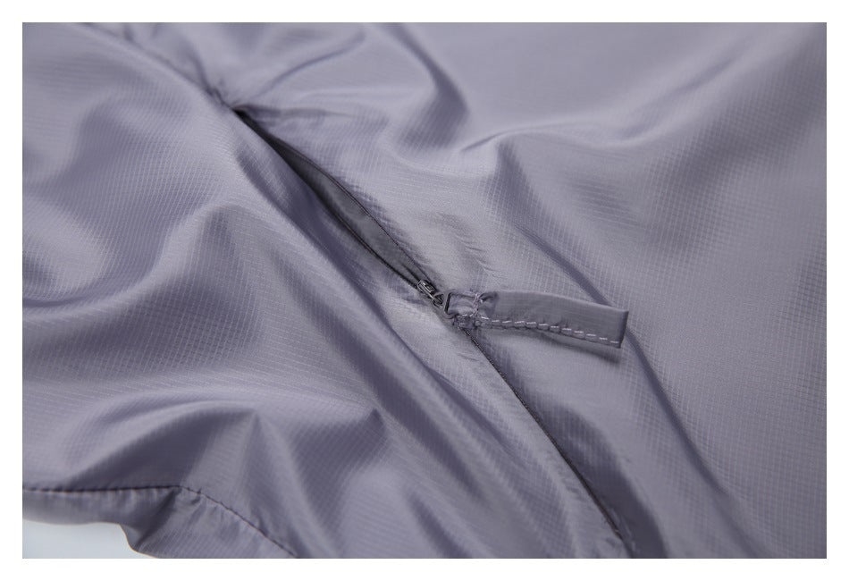 Close-up of a small zipper and fabric pull tab on the gray-lavender jacket.