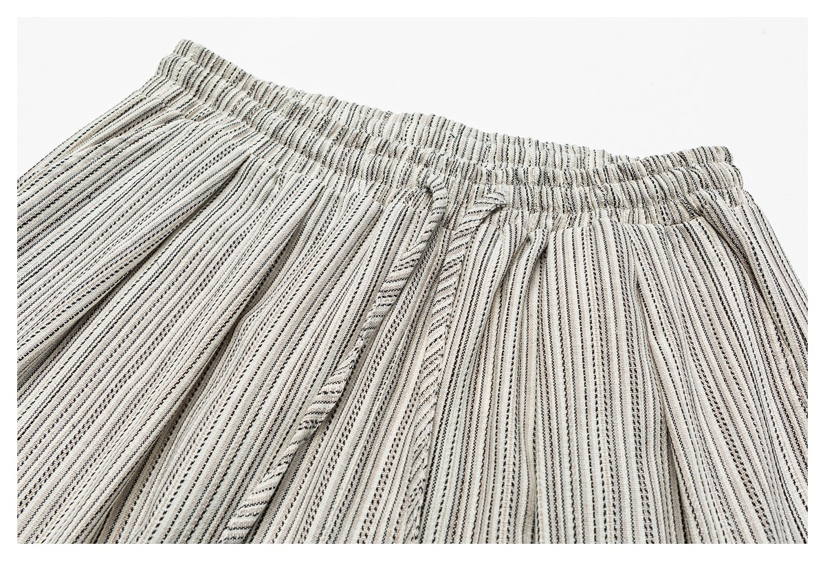Close-up of the gathered elastic waistband and matching drawstring on cream-and-black striped trousers.
