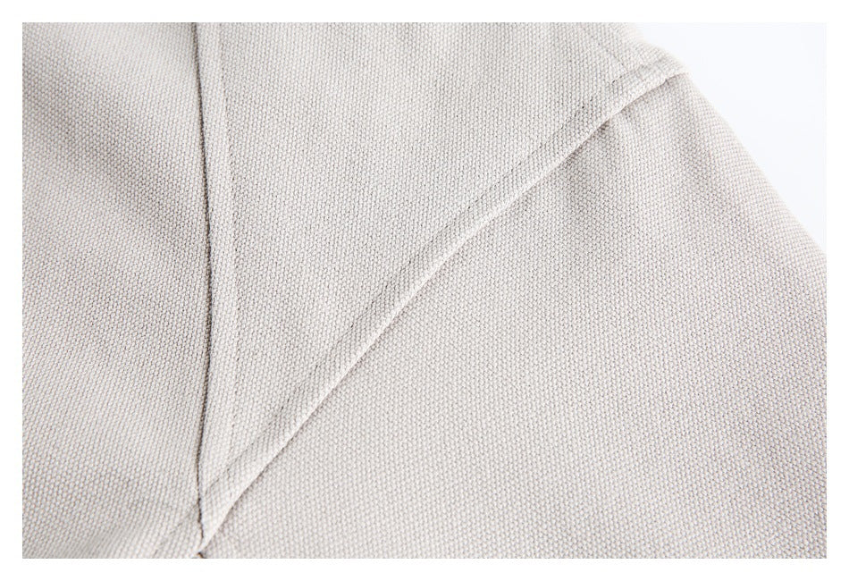Close-up of beige jacket fabric and a curved stitched seam.