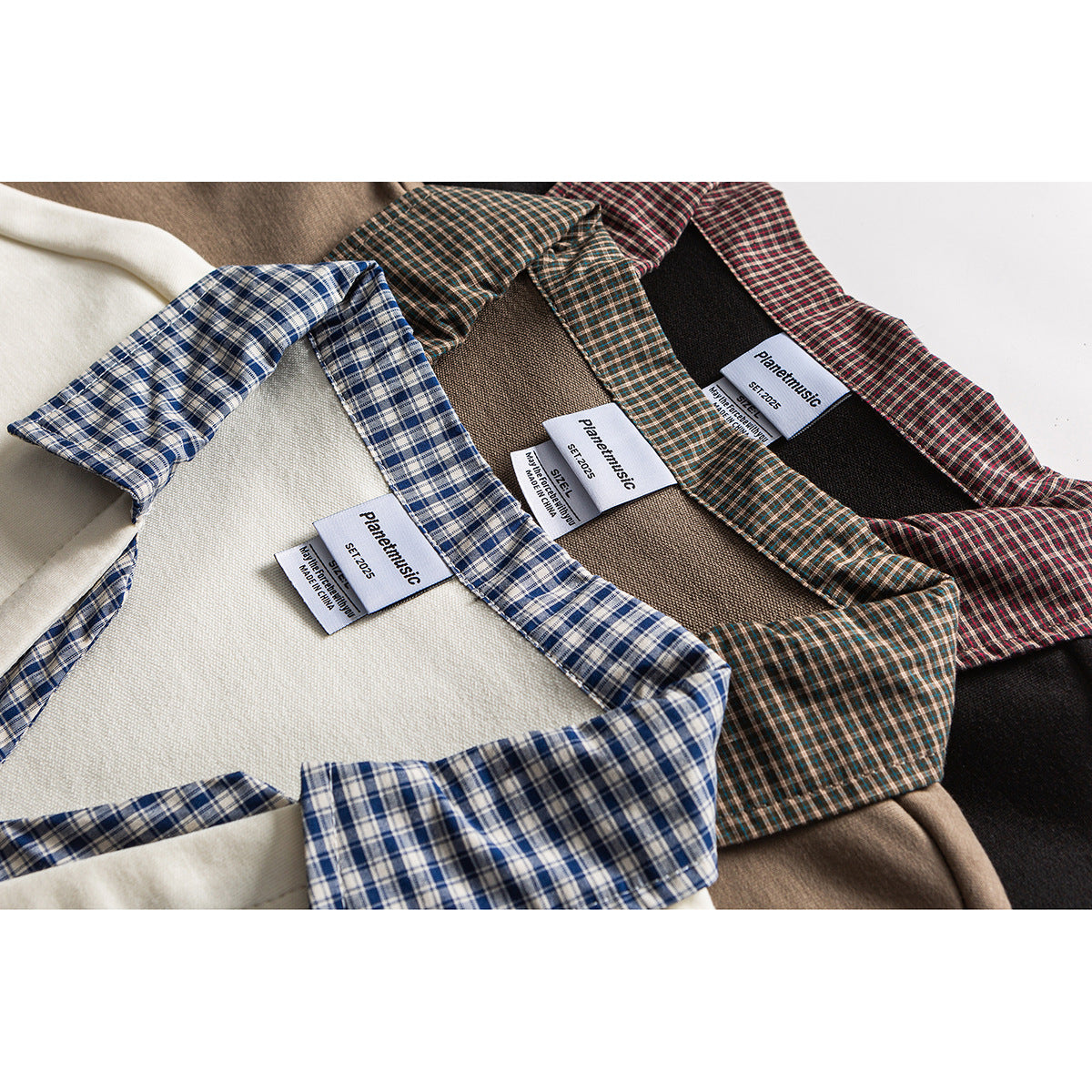 Close-up of cream, taupe, and dark tops with contrasting plaid collars and sewn-in labels.