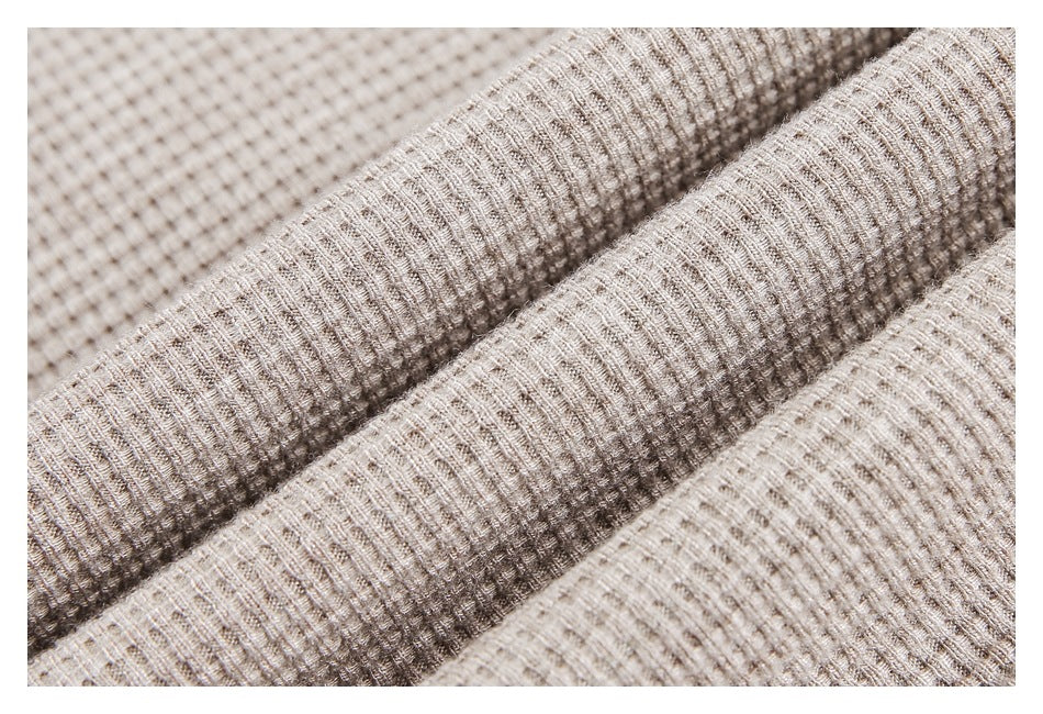 Macro view of the beige top's raised, grid-like fabric texture folded into soft ridges.