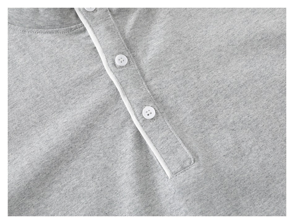 Close-up of a heather-gray shirt neckline and button placket with three white buttons.