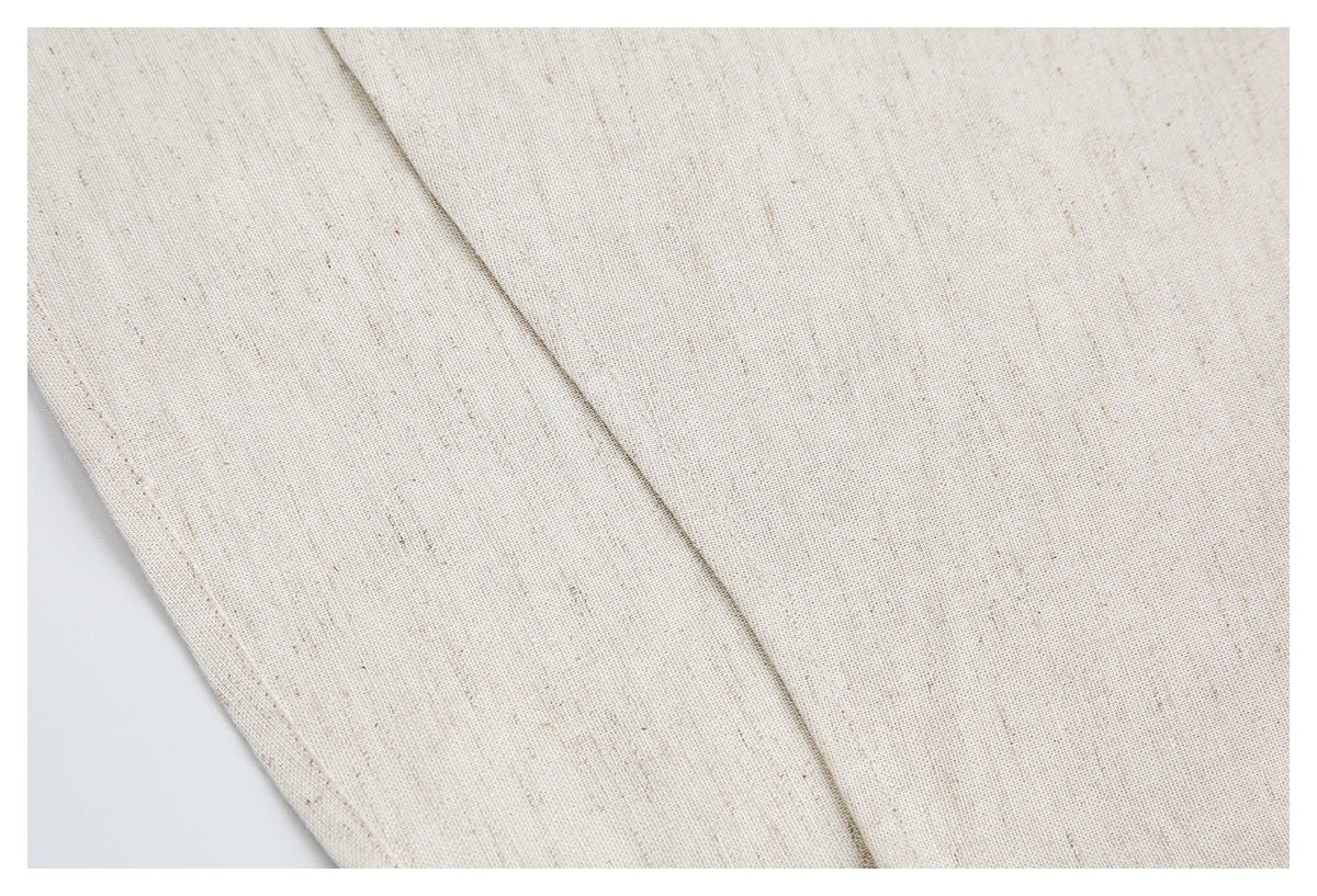 Close-up of ivory flecked garment fabric showing a long stitched seam and finished edge.