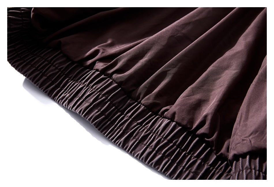 Close-up of the jacket's gathered waistband and smooth inner lining in deep plum brown.