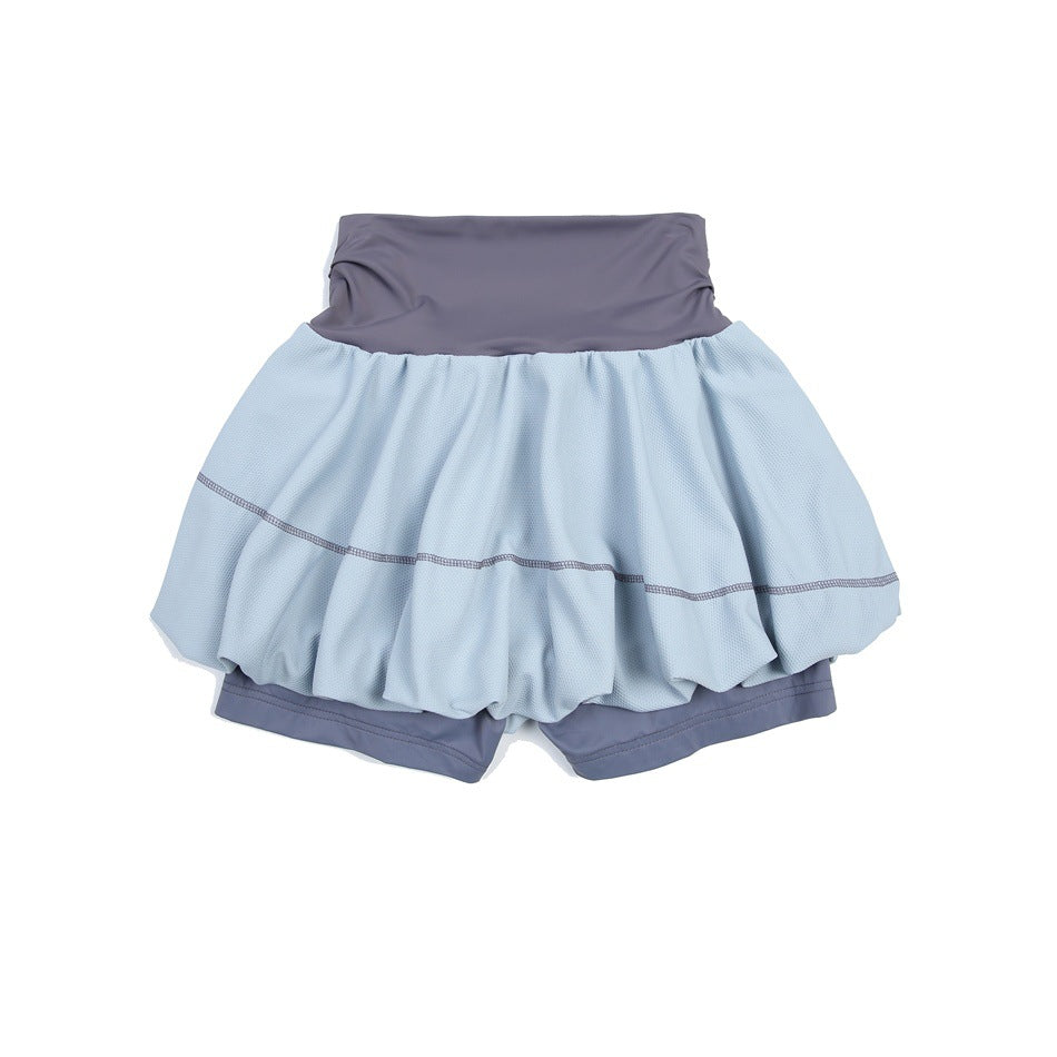 Flat lay of a pale blue bubble tennis skirt with a slate-purple waistband and matching built-in shorts.