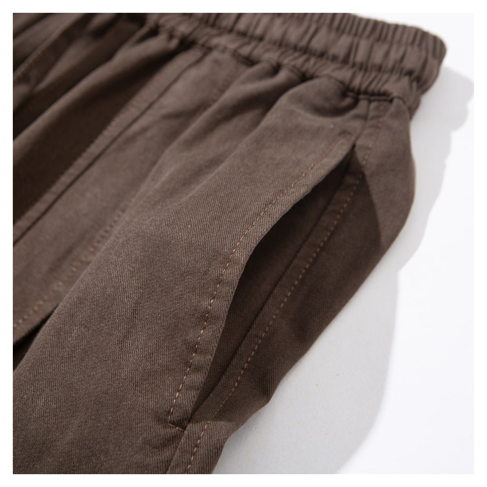Close-up of a brown pants side pocket and its stitched opening.
