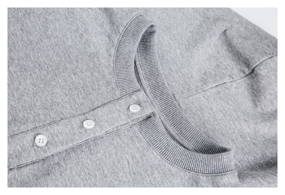 Close-up of a heather gray knit top with a ribbed crew neckline and three-button placket.
