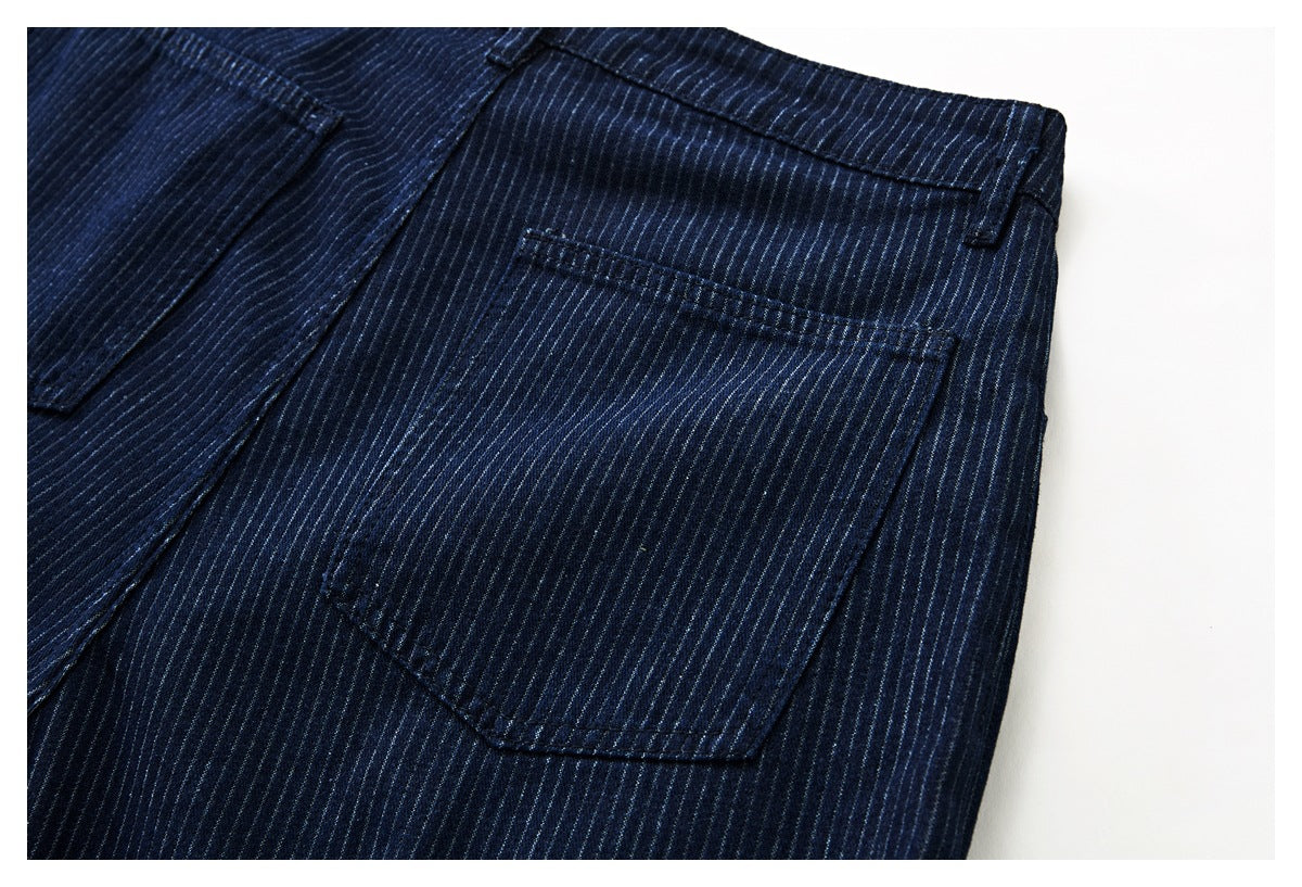 Close-up of a back pocket and belt loop on dark navy pinstriped trousers.