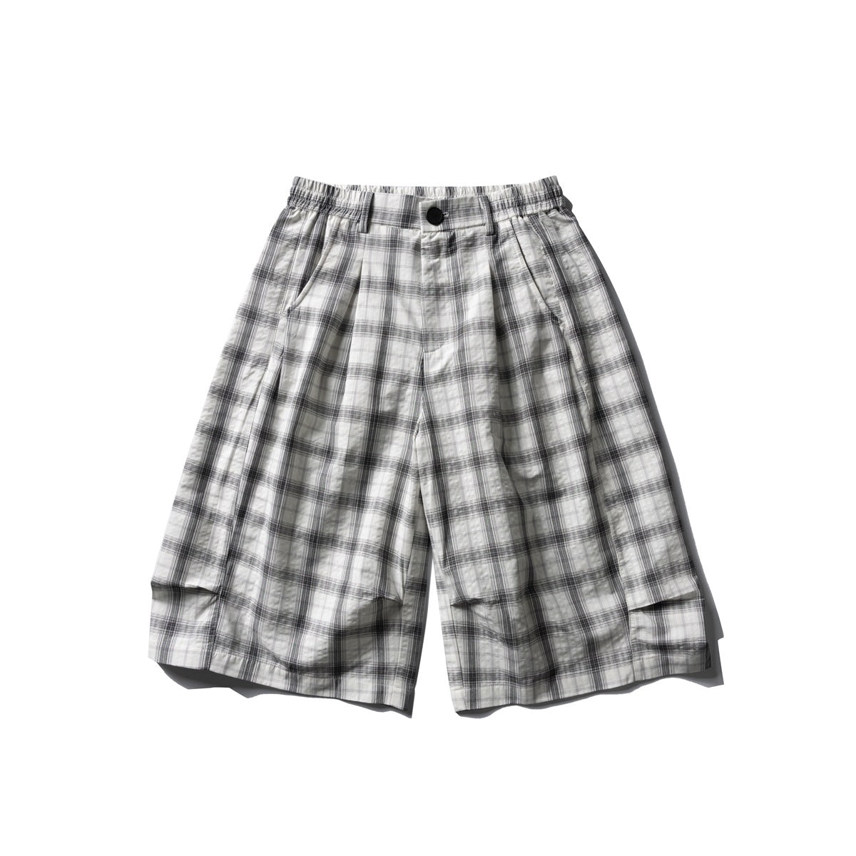 White and gray plaid knee-length wide-leg shorts with front pleat, black button and elastic waistband, flat lay front